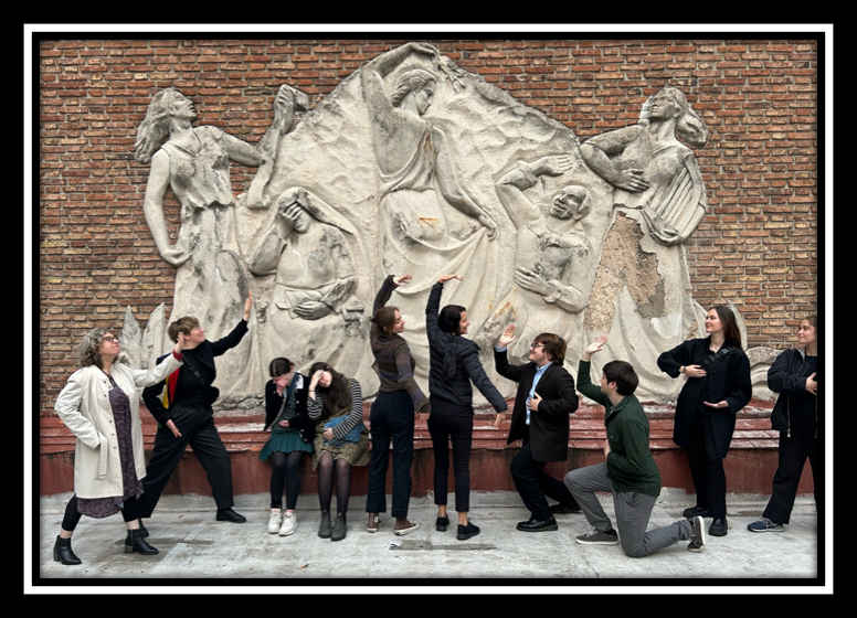 Students posing in front of a memorial